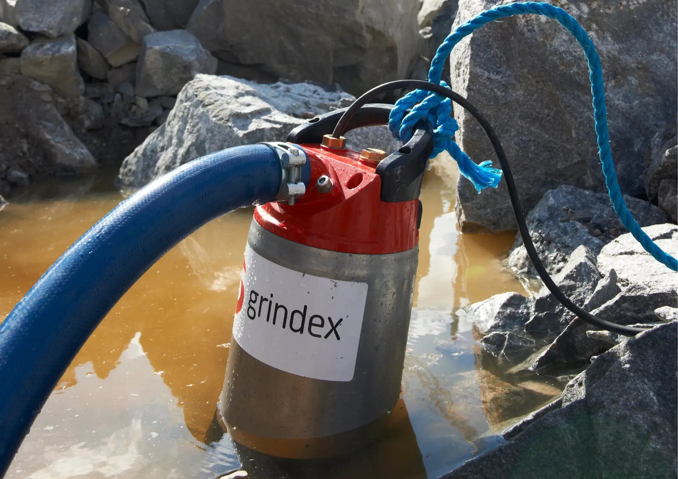 grindex submersible pump semi submerged in dirty water