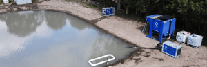 Prime water quality monitoring and treatment equipment beside a water retention pond in New Zealand